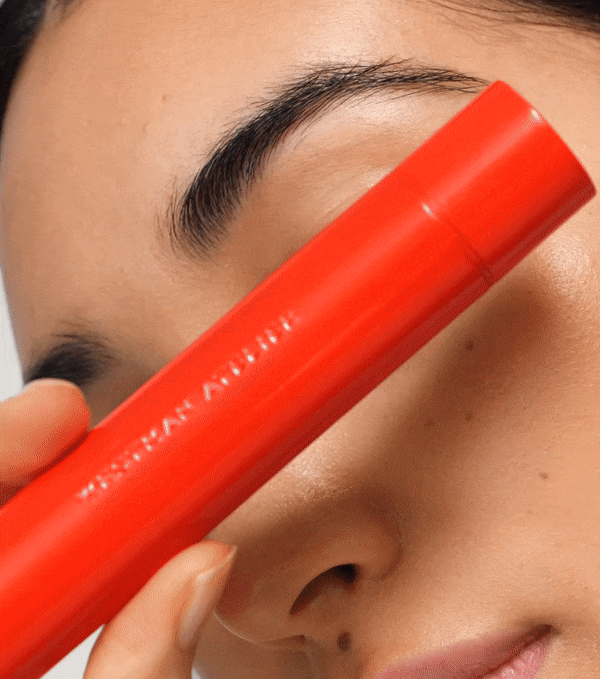 Model applies black mascara to her lashes.