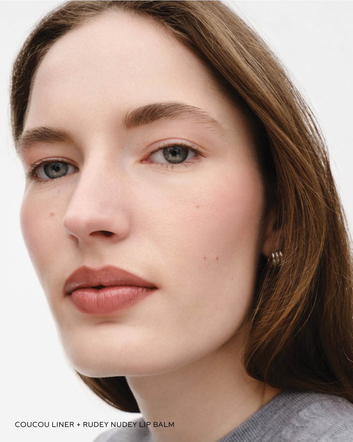 Model wears lip liner in Coucou and lip balm in Rudey Nudey.