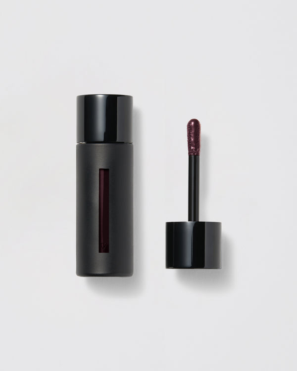 Black lip gloss container with applicator on a gray background