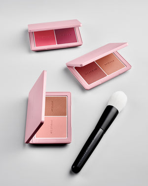 Powder II Brush pictured alongside the Baby Cheeks Powder Blush Duo palettes on a grey background. 