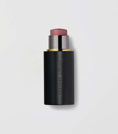 Black makeup stick with pink top on a light gray background.