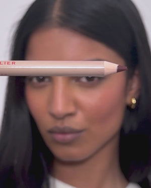 Model applies lip liner in Lou Lou. 