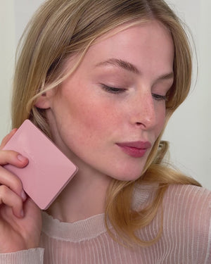 Blonde model applies the Baby Cheeks Powder Blush Duo in Coquette / Mimi. 