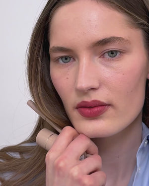 Model applies lip liner in Petal and lipstick.