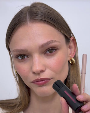 Model applies lip liner in Petal and lip balm. 