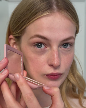 Blonde model applies the Powder Duo in Petal / Biscuit.