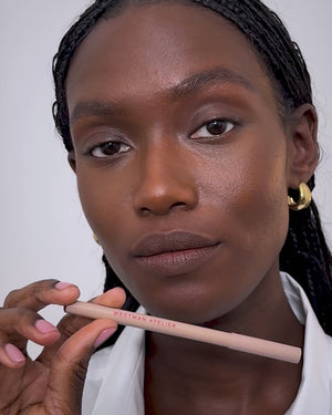 Model applies lip liner in Mink. 